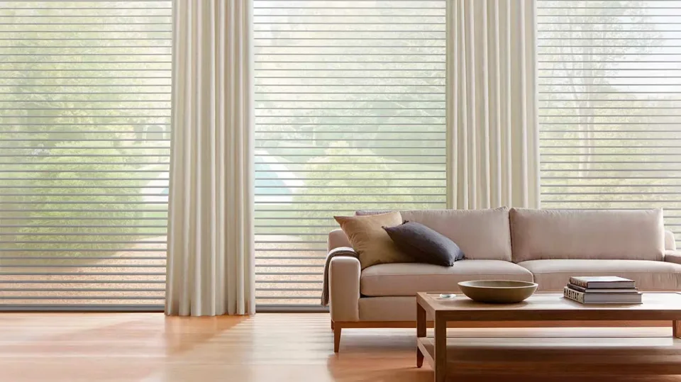 Full-length drapery and shades softly filtering daylight in a refined living room