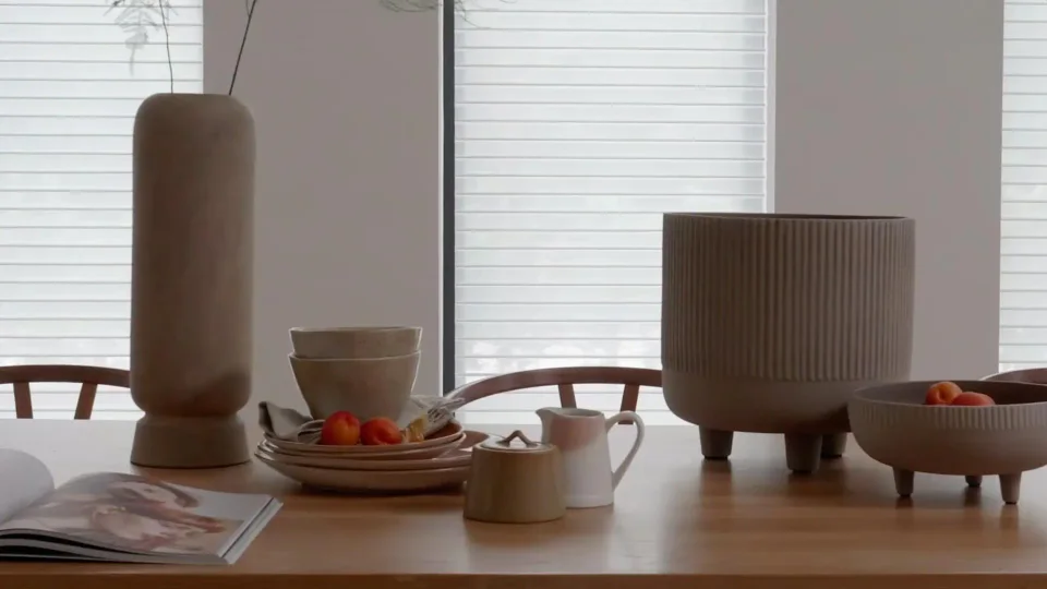 Soft light through shades beside a dining table